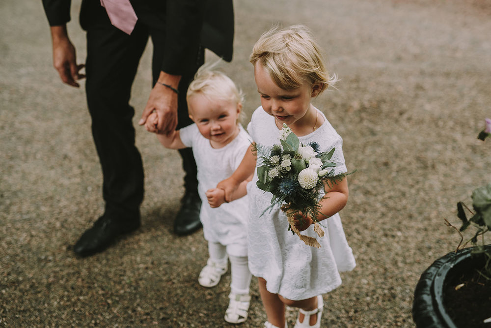 Barn i vita klänningar med blombukett