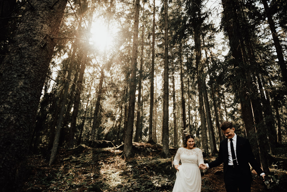 brudpar går i skog under bröllopsfotografering i skog i stockholm
