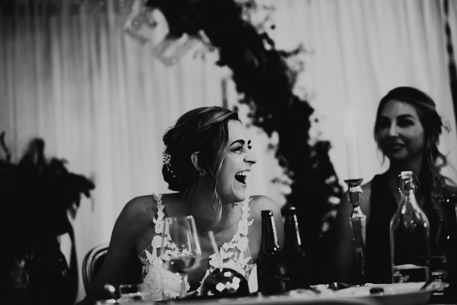 brud skrattar under tal på deras bröllop på fjelldalens slott