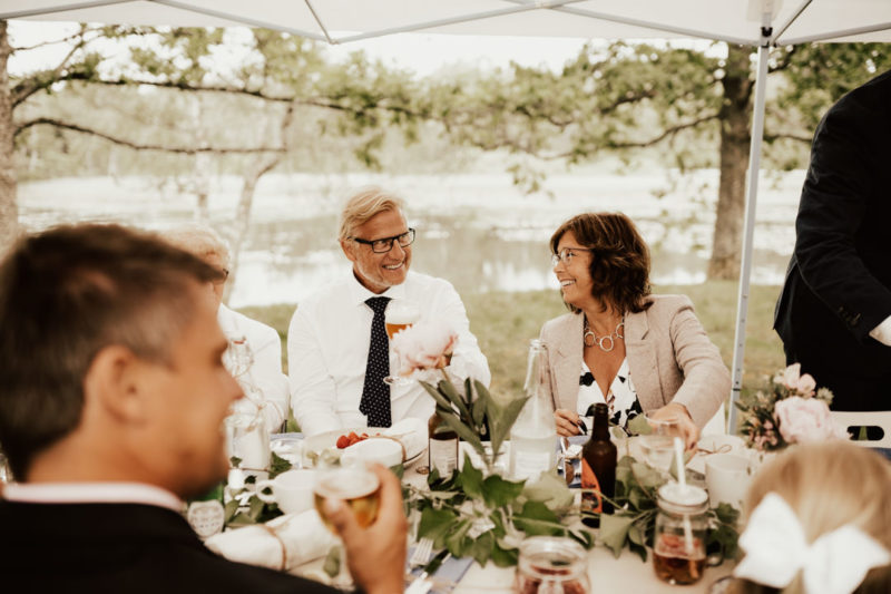 gäster skrattar på midsommarbröllop