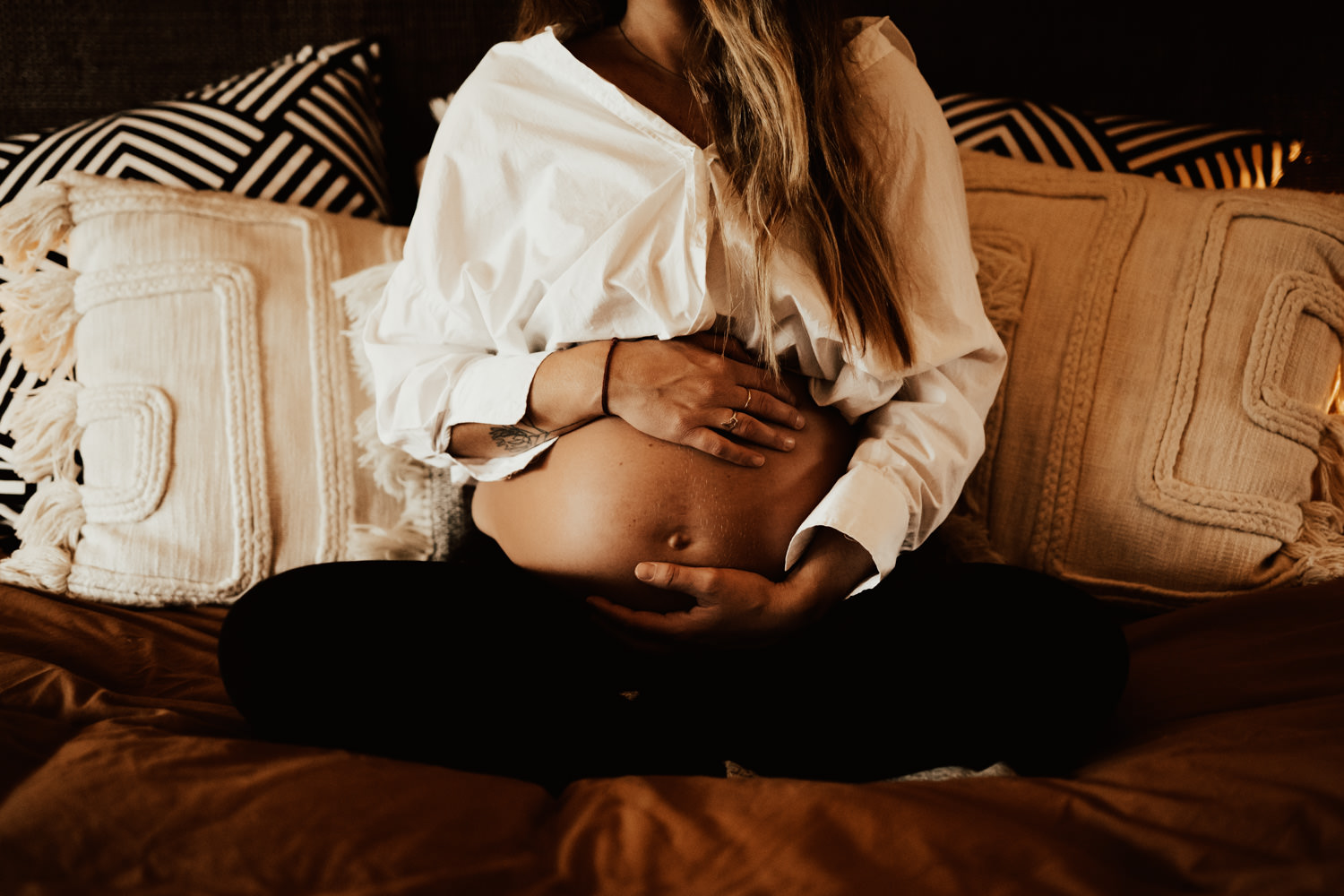 Gravid håller om mage under gravidfotografering