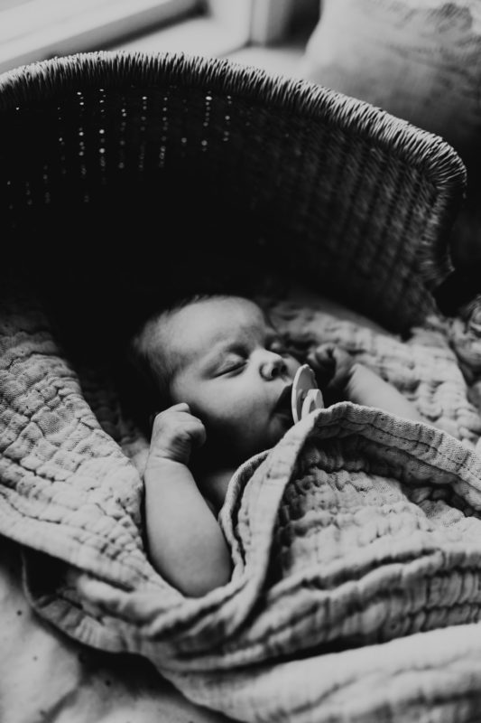 Nyfödd bebis sover i bohemisk korg