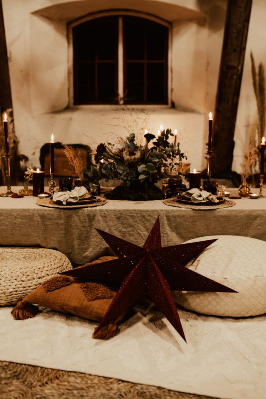 Röd julstjärna framför juldukat bord