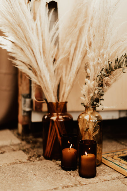 Pampas grass and dried flowers in brown glass jar as wedding decor on a boho festival wedding in Germany