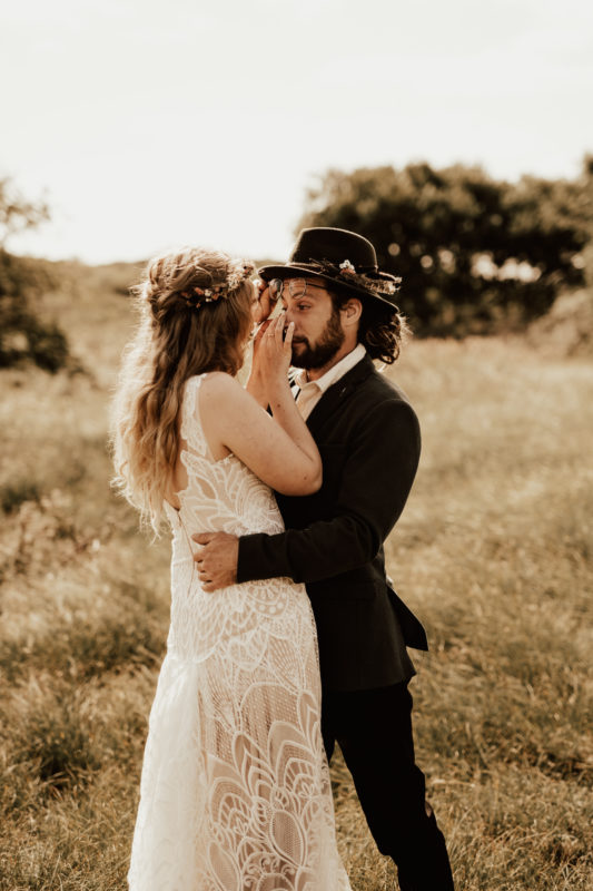 Bride dries grooms tears during their first look at their boho wedding in Borkum Germany