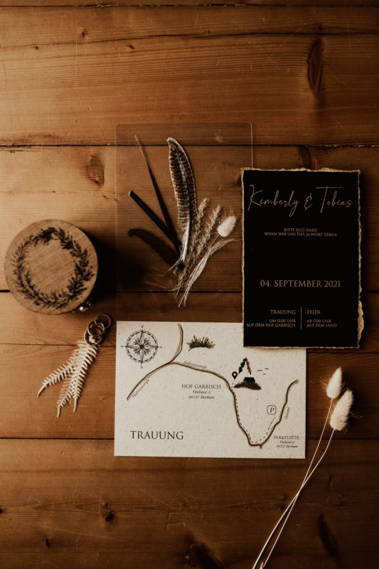 Bohemian wedding stationary flatlay with rings and a handmade wooden ring box.