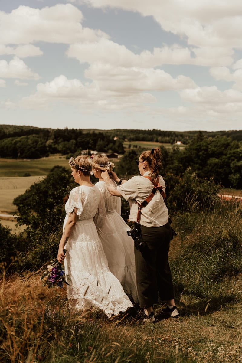 bröllopsfotograf hjälper brudpar med blomsterkransar under bröllopsfotografering i Göteborg