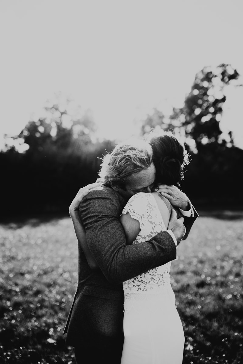 brudgum kramar om brud i höstsolen på en äng i halmstad