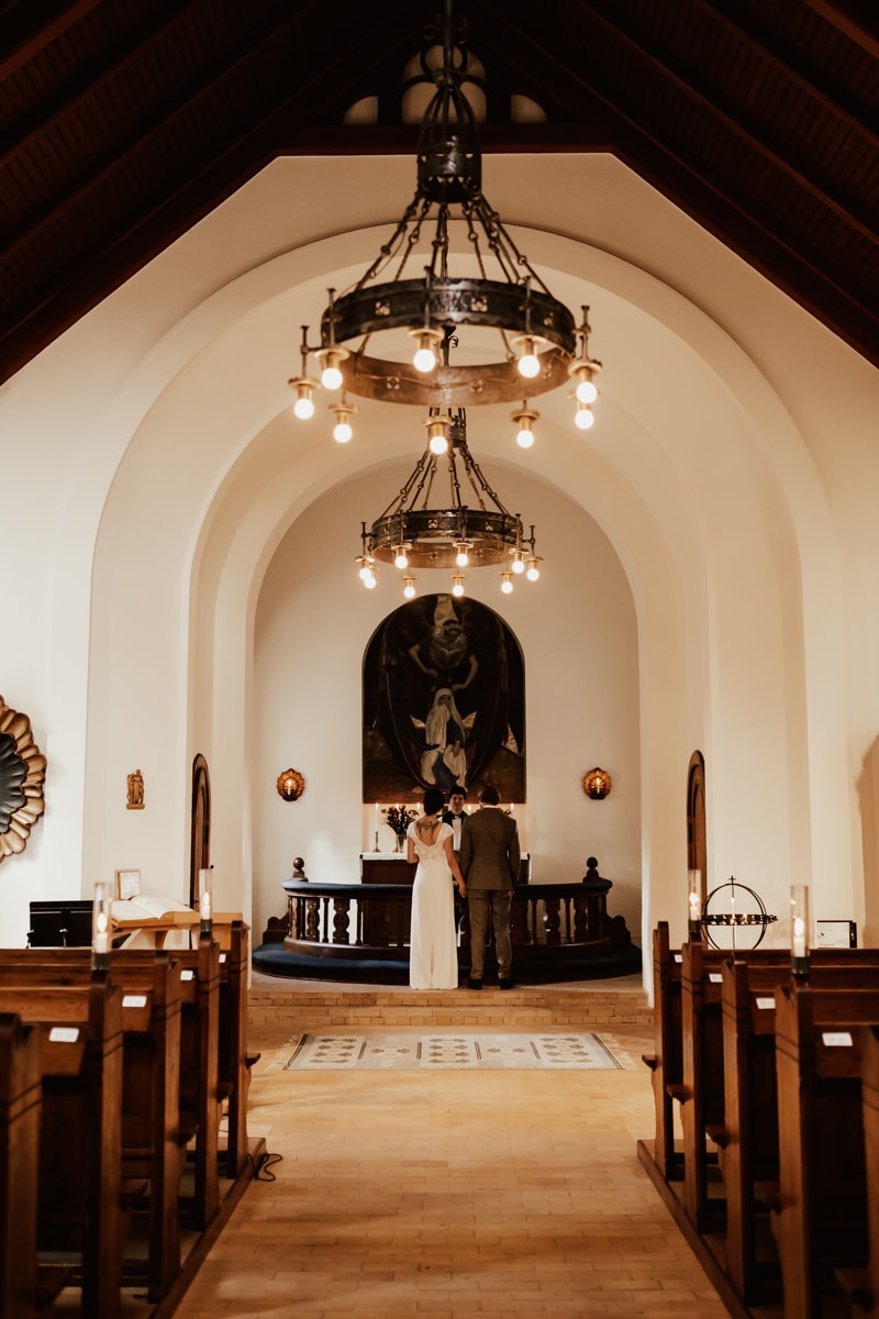 brudpar står framme vid altaret under hemligt bröllop i sperlingsholms kyrka